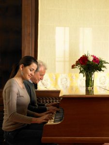 Senior father and daughter playing duet